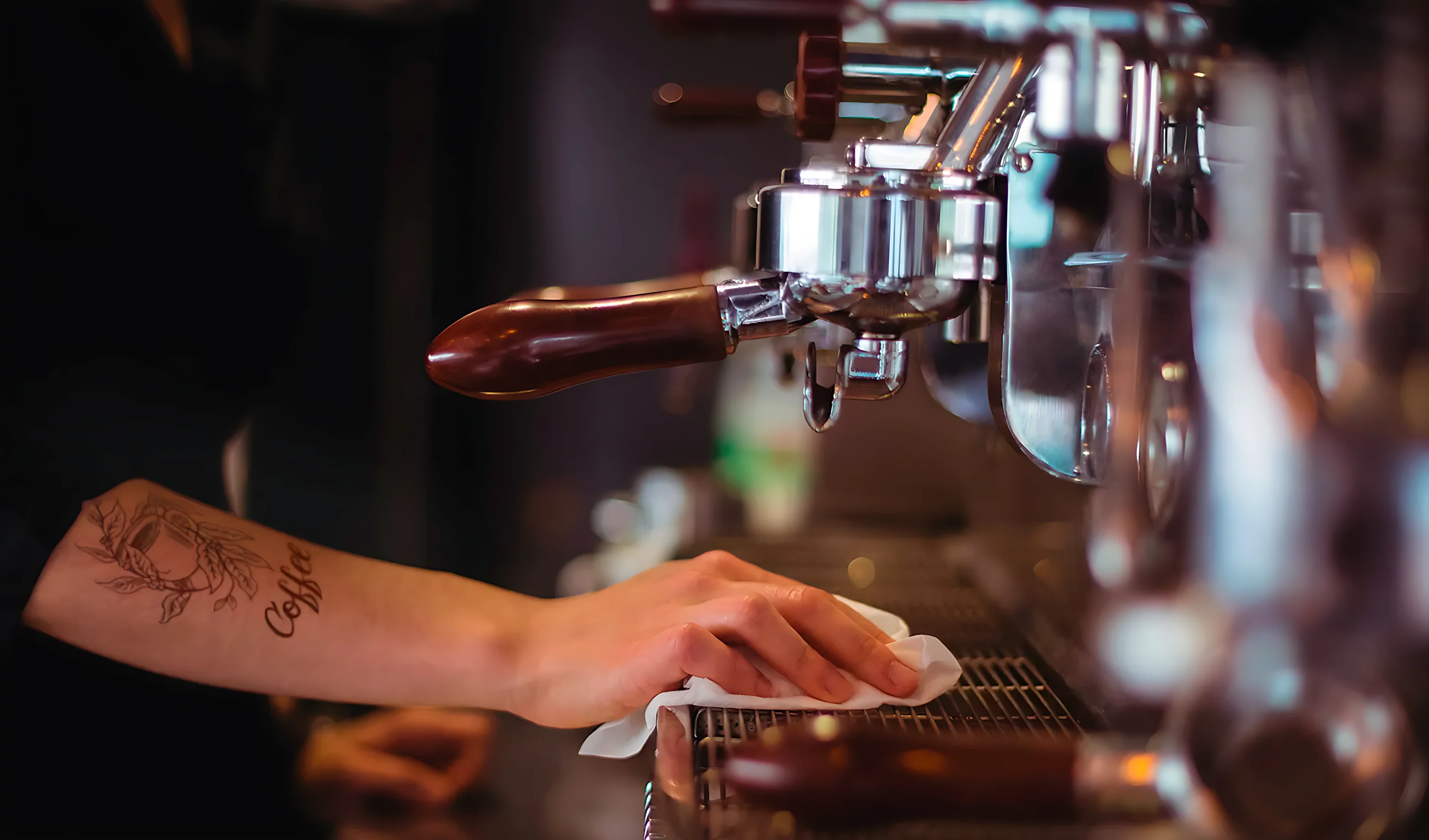 Barista dando mantenimiento a una máquina de espresso