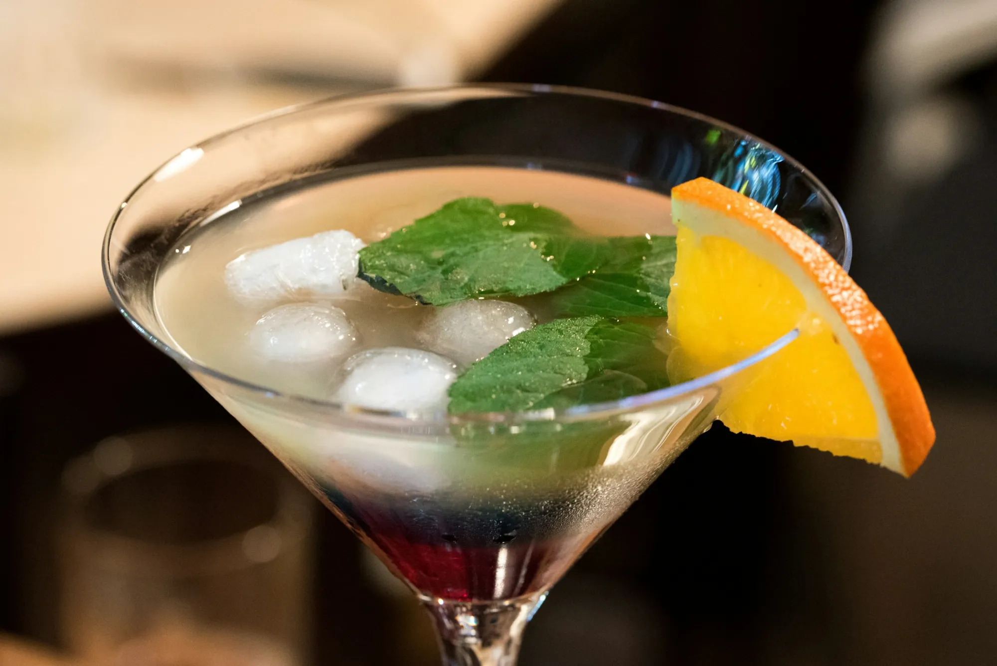 Coctel servido con hielo y una rodaja de naranja