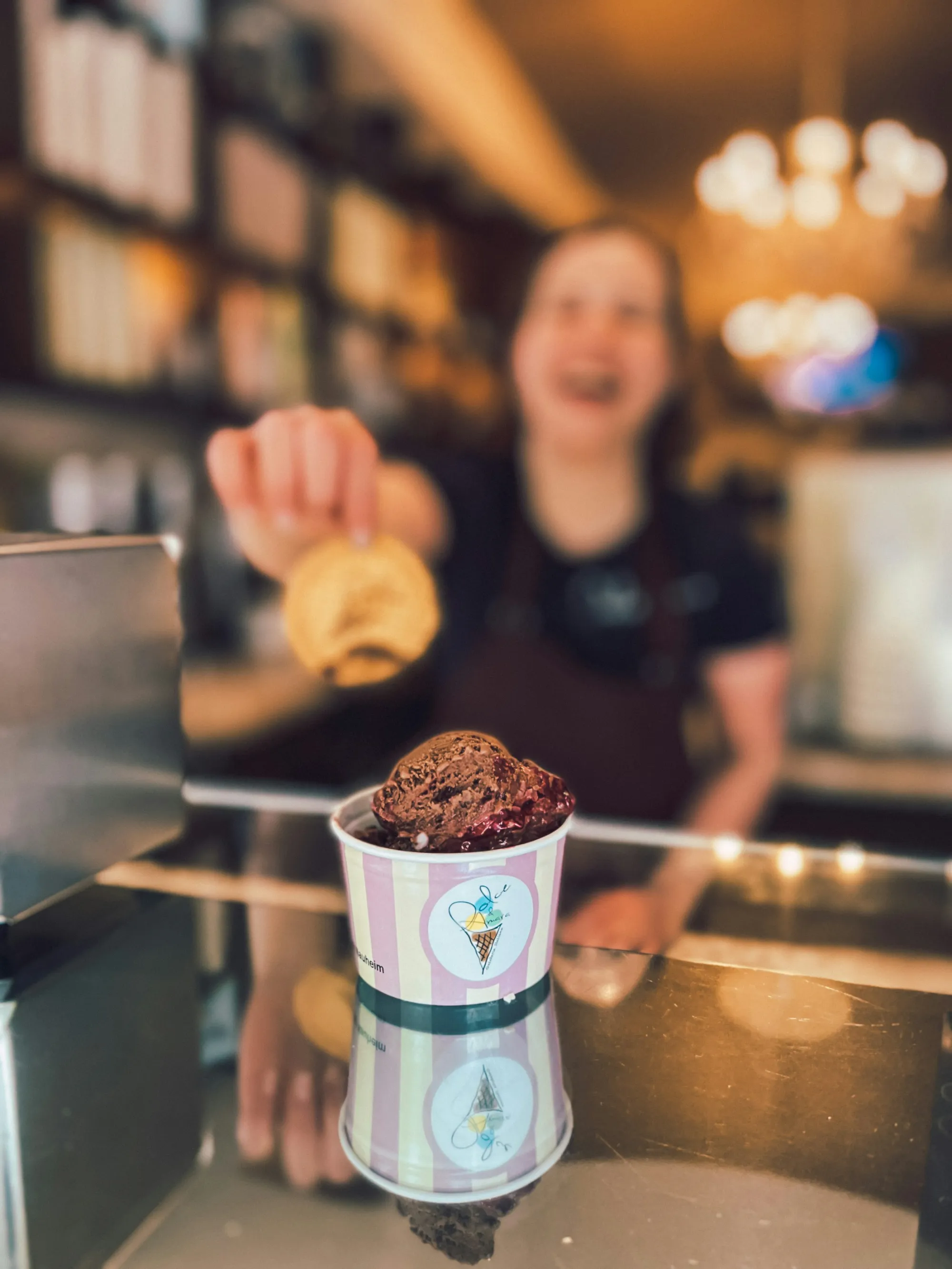 Persona sonriendo mientras sirve un vaso de gelato