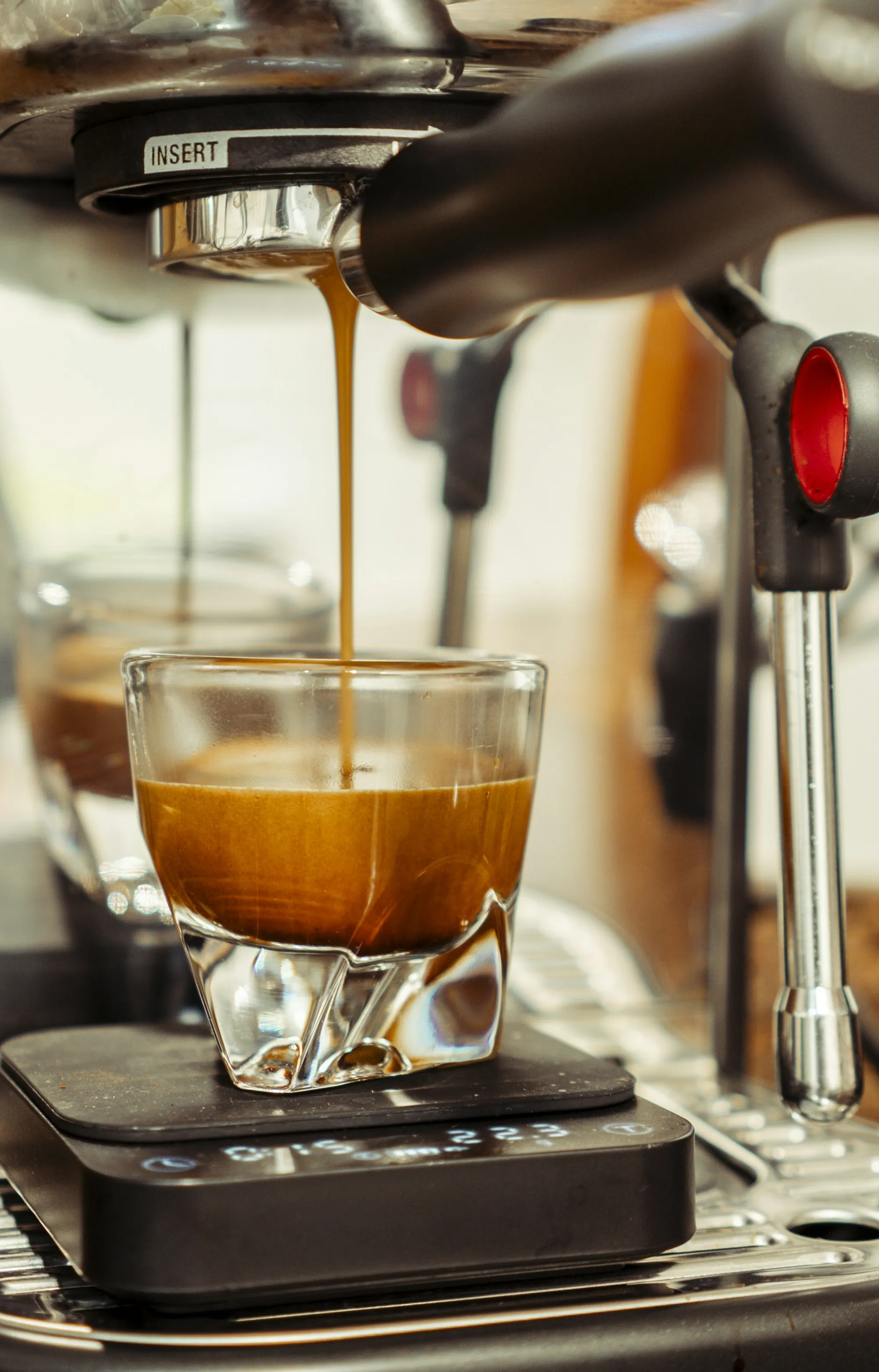 Extracción de espresso en vaso de vidrio sobre báscula