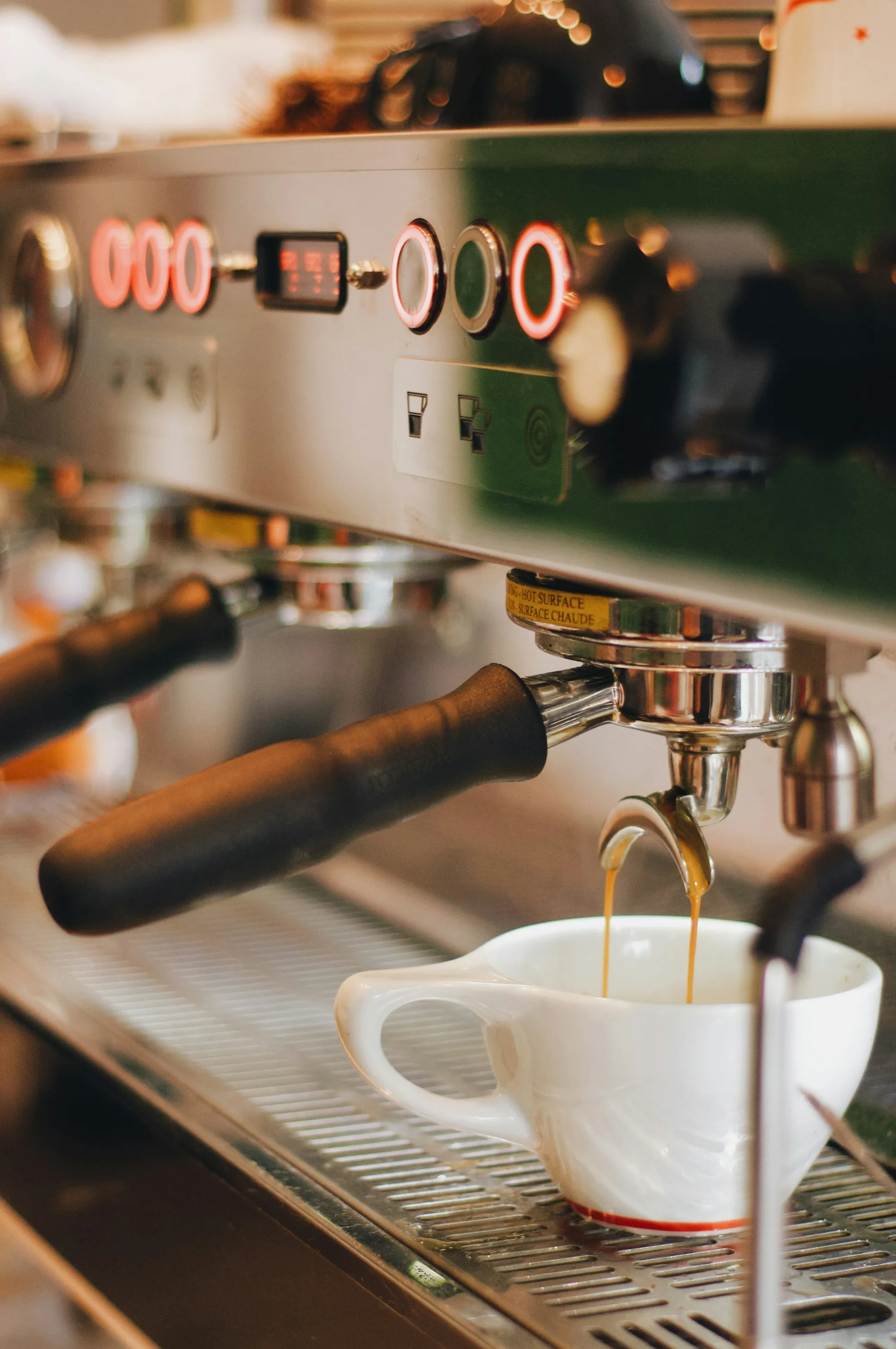 Máquina de espresso de acero en una cocina con taza recién servida